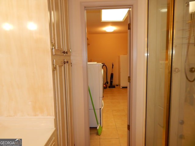 bathroom featuring washer / dryer, tile patterned flooring, and an enclosed shower