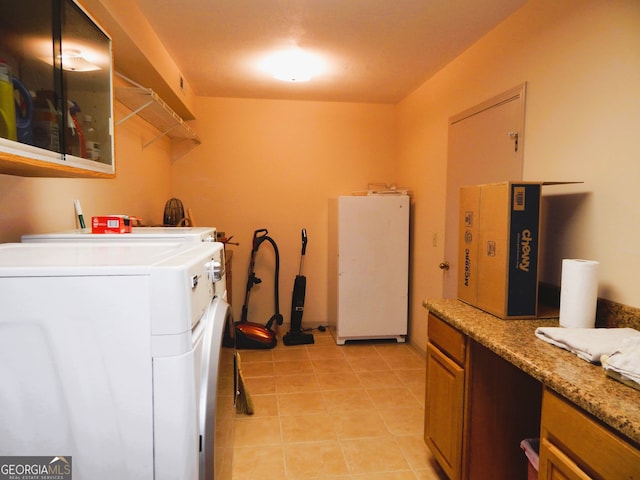 laundry area with light tile patterned floors and washing machine and dryer