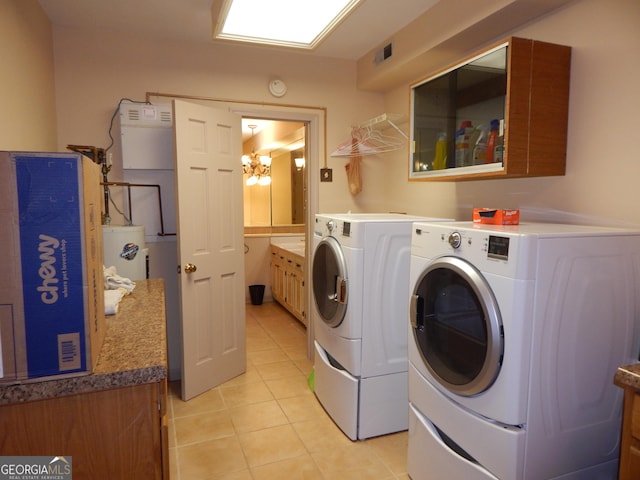 381 Hidden Lakeview Cir, Hiawassee, GA 30546 - laundry area with washing machine and clothes dryer, light tile patterned floors, a chandelier, water heater, and cabinet space