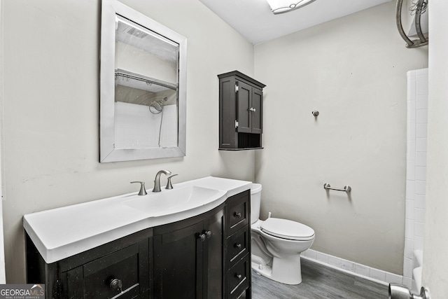 full bathroom with wood-type flooring, vanity, bathtub / shower combination, and toilet