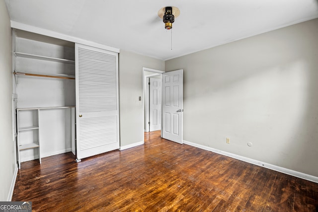 unfurnished bedroom with a closet and dark hardwood / wood-style floors