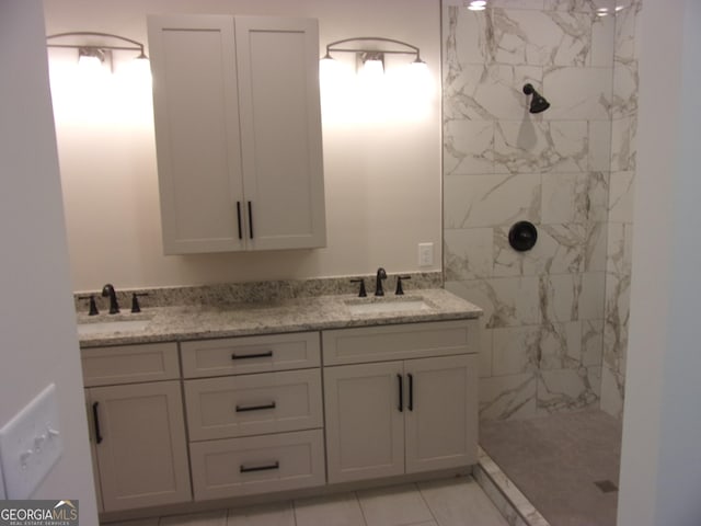 bathroom with vanity, a tile shower, and tile patterned floors