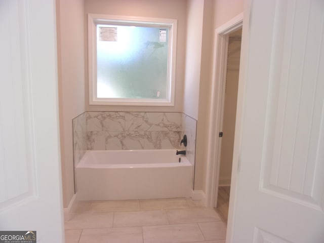 bathroom featuring a bathtub, tile patterned floors, and a wealth of natural light