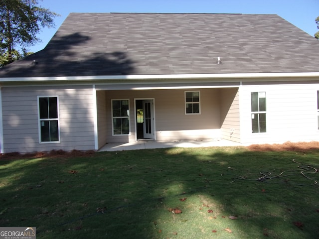 back of house with a lawn and a patio