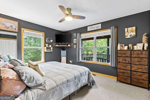 bedroom with multiple windows, ceiling fan, and carpet floors