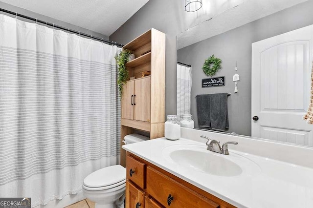 bathroom featuring a shower with shower curtain, a textured ceiling, vanity, and toilet