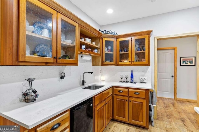 kitchen featuring light hardwood / wood-style floors, decorative backsplash, black dishwasher, and sink