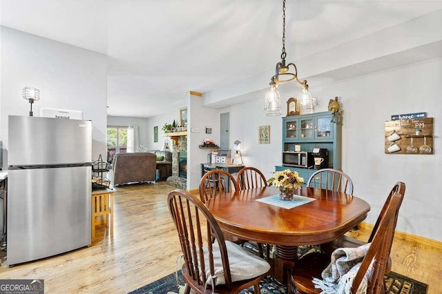 dining room featuring light wood-type flooring and a fireplace