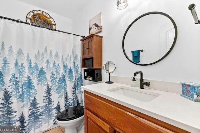 bathroom with tile patterned flooring, vanity, and toilet