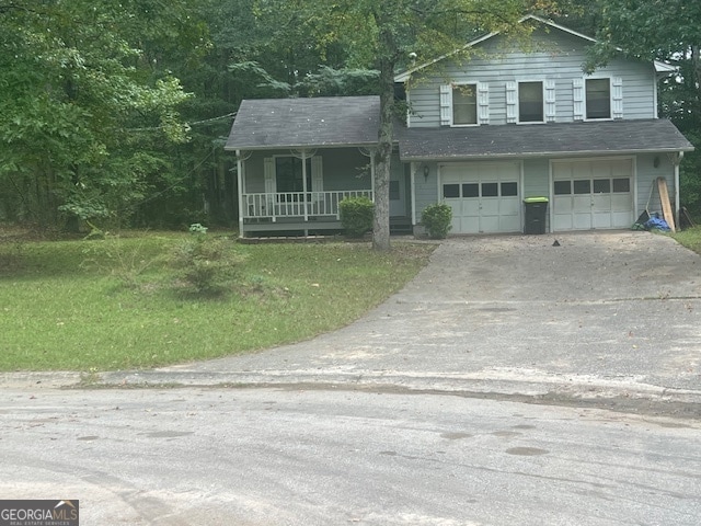 view of front facade featuring a front yard, a porch, and a garage