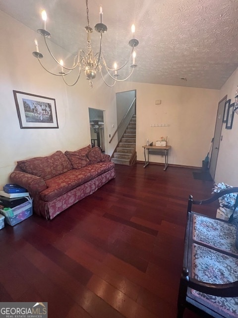 living room featuring a notable chandelier, a textured ceiling, and hardwood / wood-style floors