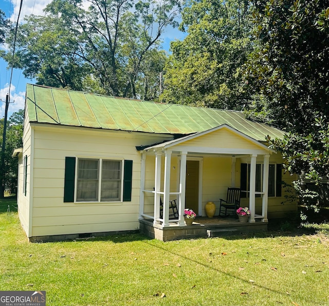 rear view of property with a lawn and a porch