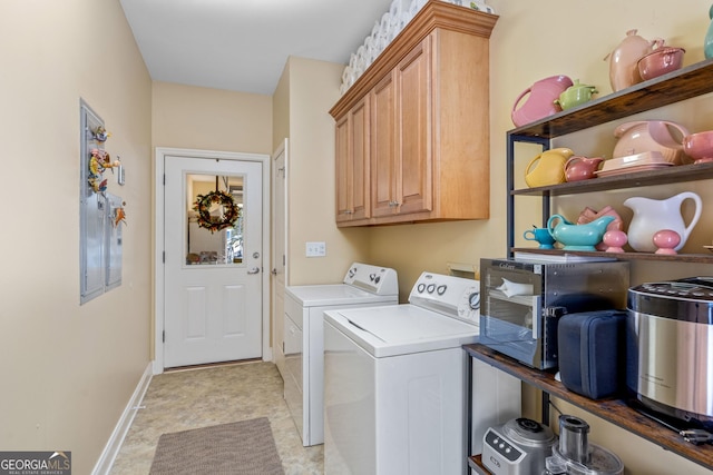 laundry area with separate washer and dryer and cabinets