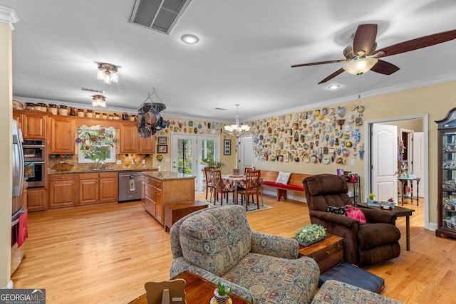 living room with sink, crown molding, light hardwood / wood-style flooring, and ceiling fan with notable chandelier