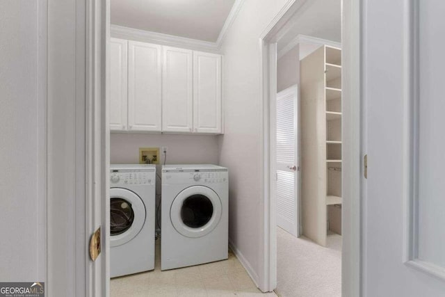 washroom featuring ornamental molding, cabinets, and washing machine and dryer