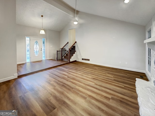 unfurnished living room featuring vaulted ceiling with beams and hardwood / wood-style flooring