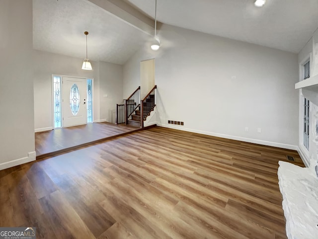 foyer featuring stairway, vaulted ceiling with beams, wood finished floors, baseboards, and visible vents