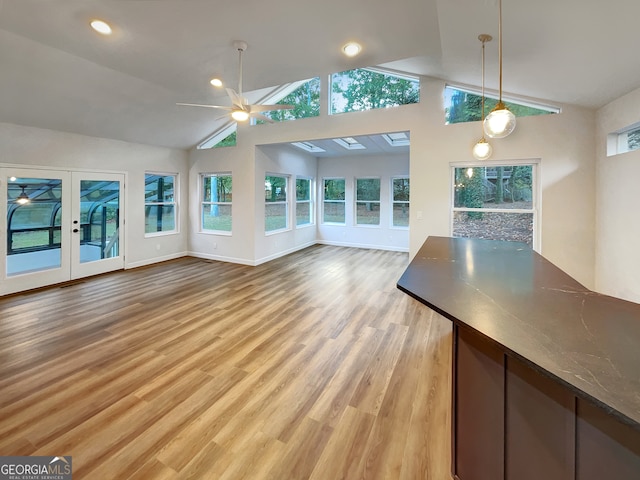 unfurnished living room featuring high vaulted ceiling, light wood-type flooring, and ceiling fan