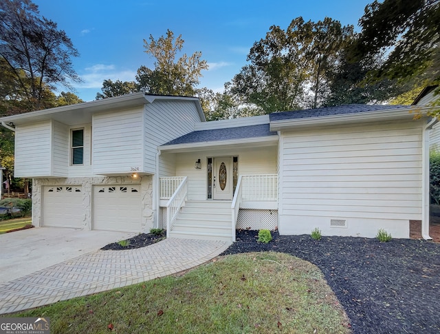 tri-level home featuring a garage and covered porch