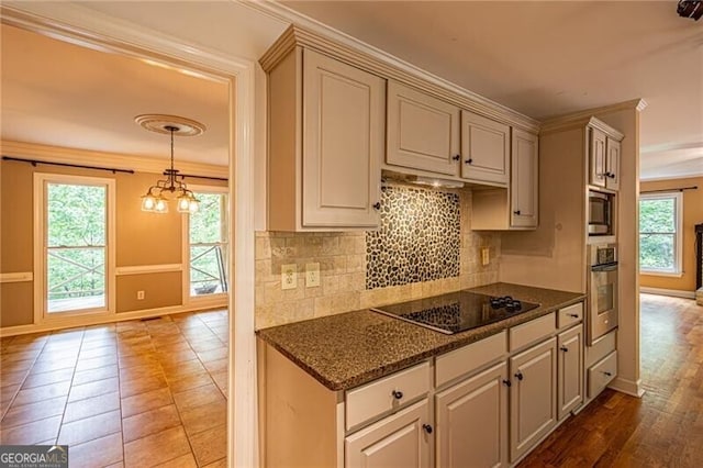 kitchen with pendant lighting, tasteful backsplash, an inviting chandelier, stainless steel appliances, and ornamental molding