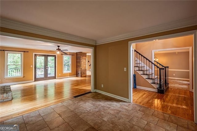 empty room featuring ceiling fan, light wood-type flooring, crown molding, and french doors