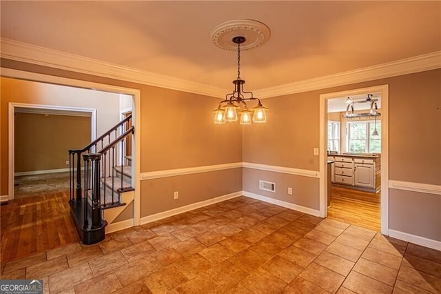 unfurnished room featuring ornamental molding, a notable chandelier, and hardwood / wood-style floors