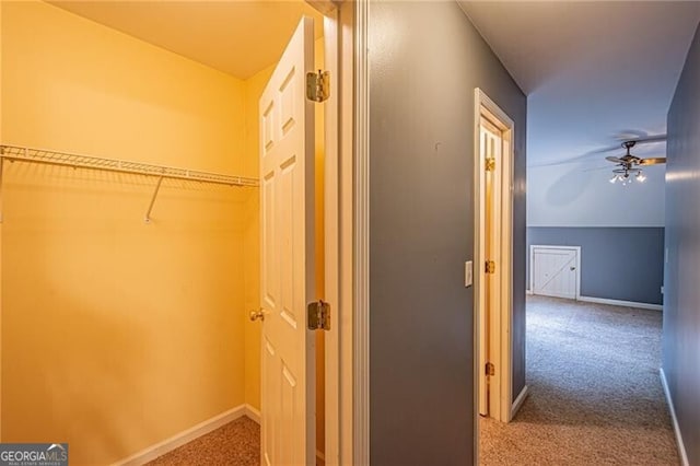 interior space featuring carpet flooring, vaulted ceiling, and ceiling fan