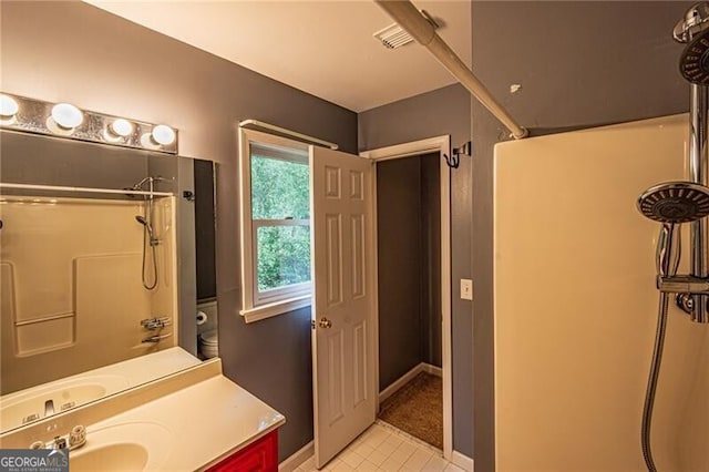 bathroom featuring vanity, a shower, and tile patterned flooring