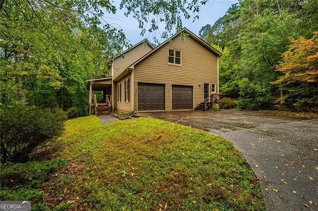 view of side of home with a garage, a yard, and covered porch