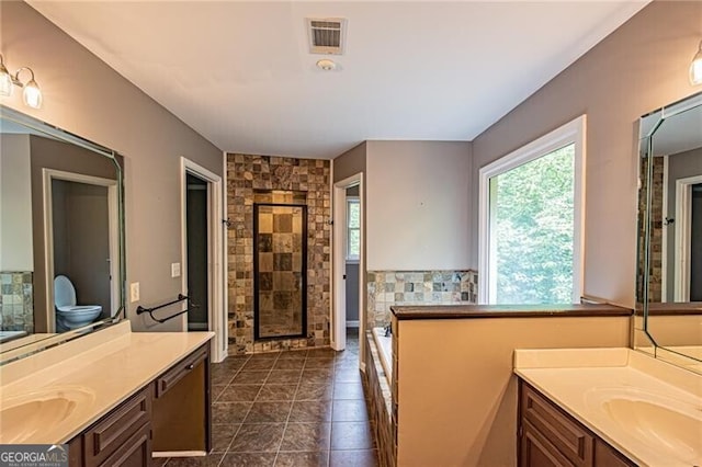 bathroom with tile patterned floors, walk in shower, vanity, and toilet