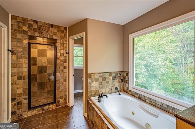 bathroom featuring tile patterned flooring, independent shower and bath, and a healthy amount of sunlight