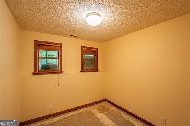 unfurnished room with a textured ceiling