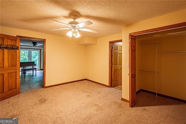 unfurnished bedroom featuring a closet, ceiling fan, light colored carpet, and a textured ceiling