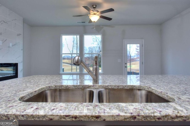 102 Greenview Ct Unit 1603, Homer, GA 30547 - kitchen view of light stone counters, ceiling fan, and a fireplace