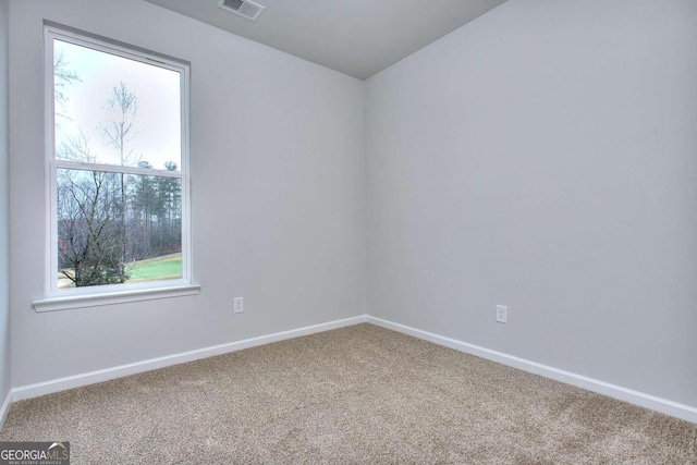 spare room with baseboards, visible vents, and carpet flooring
