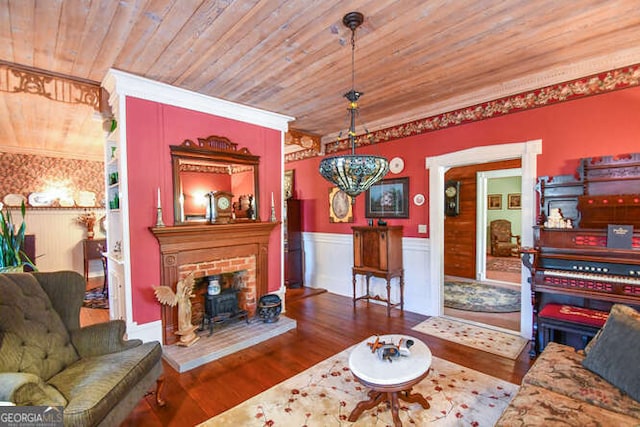 living room featuring wooden ceiling, hardwood / wood-style flooring, ornamental molding, and a brick fireplace