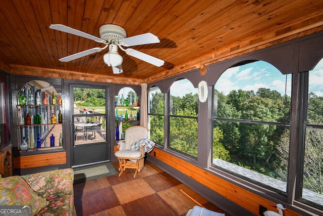 unfurnished sunroom with wood ceiling and ceiling fan