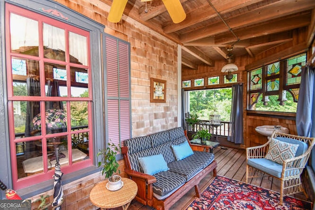 sunroom with ceiling fan, beamed ceiling, and wooden ceiling