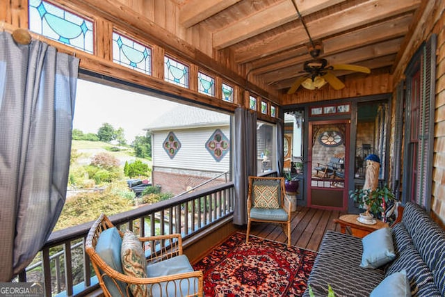 sunroom featuring ceiling fan, plenty of natural light, beam ceiling, and wooden ceiling