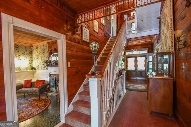 stairs featuring wood ceiling and wood walls