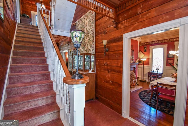 staircase featuring wood-type flooring and wood walls