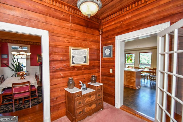 interior space with a notable chandelier, wooden walls, and hardwood / wood-style floors