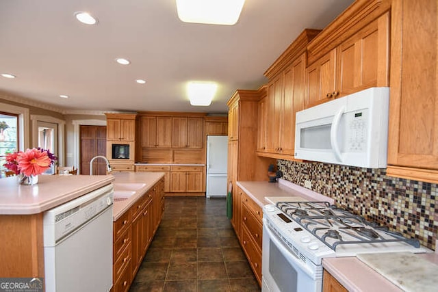 kitchen featuring a kitchen island with sink, backsplash, sink, and white appliances