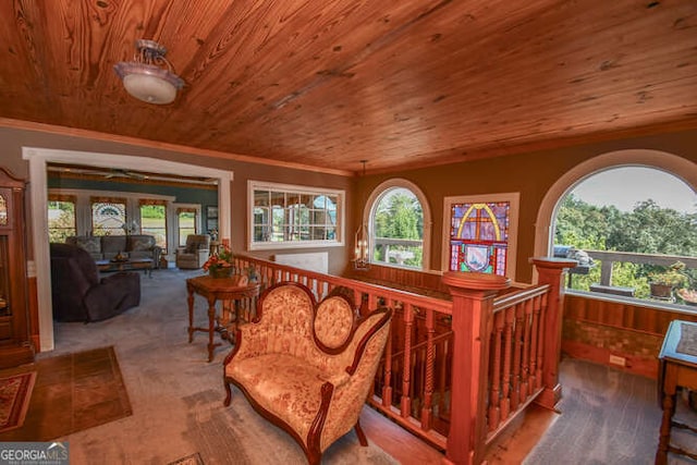 living area with wooden ceiling, wood-type flooring, and wooden walls