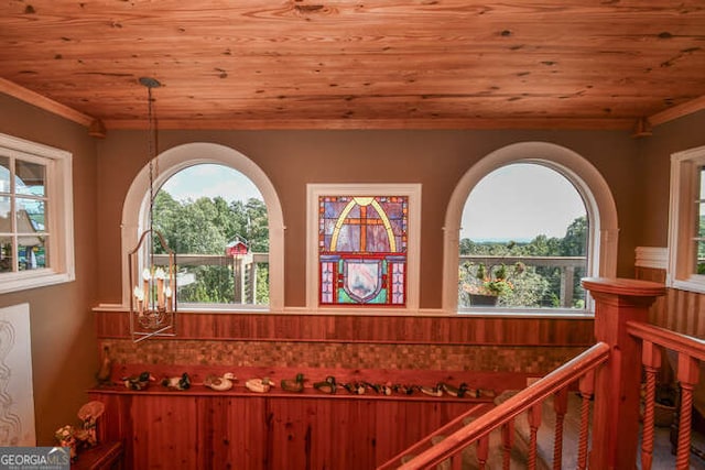 interior space featuring wooden ceiling, crown molding, and a notable chandelier