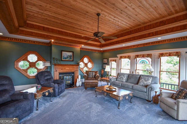 living room with carpet, wood ceiling, a tray ceiling, and ceiling fan