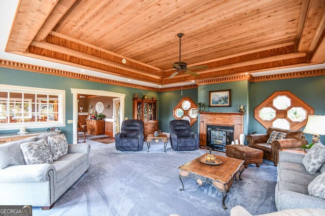 living room featuring wooden ceiling, carpet flooring, a tray ceiling, and ceiling fan