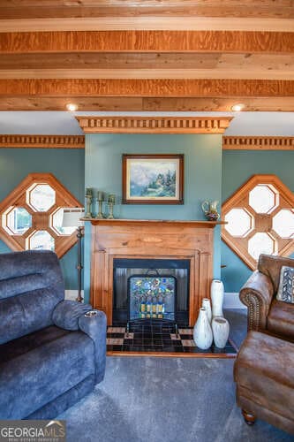 living room featuring carpet floors and beamed ceiling