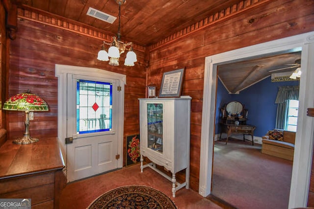 carpeted foyer with wooden walls, ceiling fan with notable chandelier, wood ceiling, and lofted ceiling