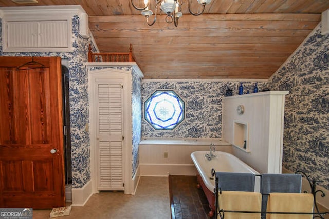 bathroom featuring wooden ceiling, a tub to relax in, vaulted ceiling, and an inviting chandelier